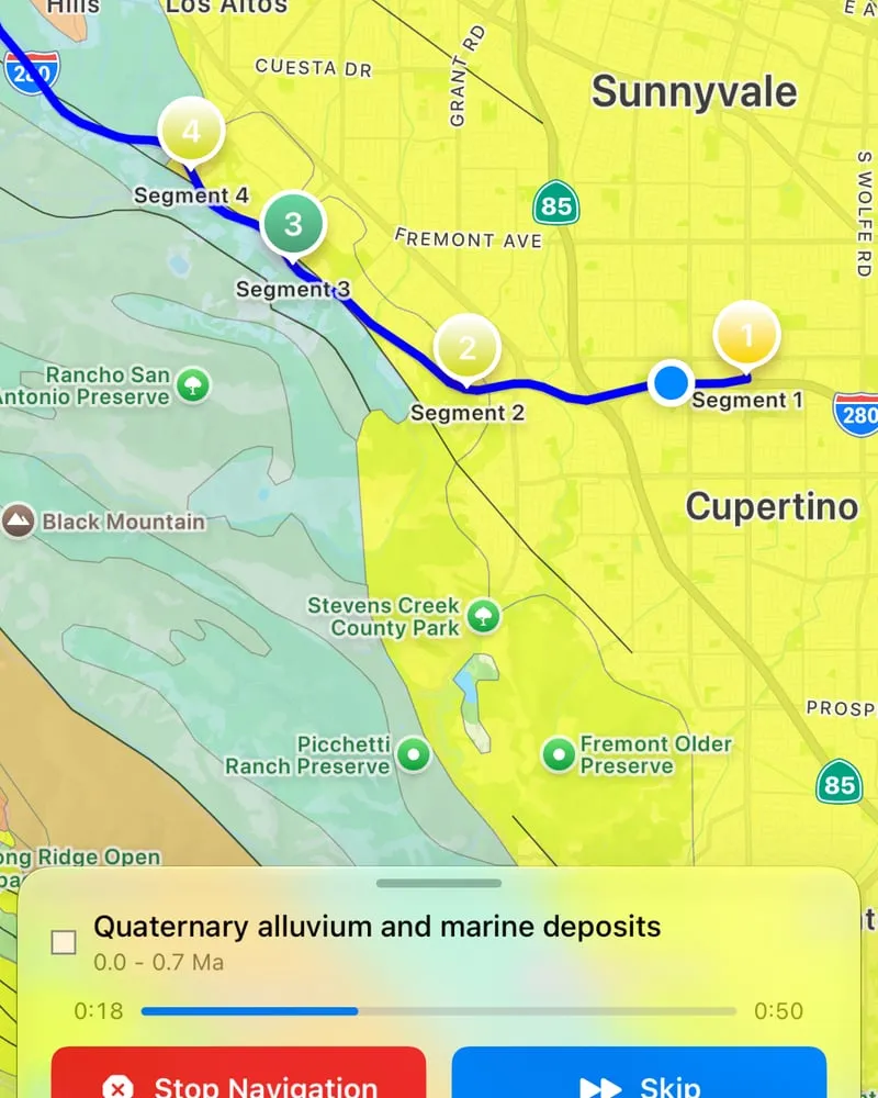 Navigating a route while the narration for the current rock unit plays, with Stop and Skip buttons